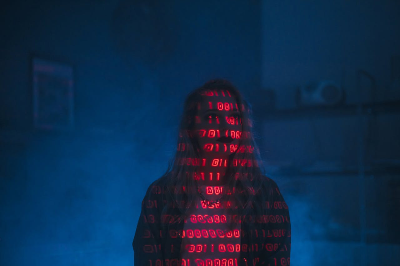 our-story A mysterious silhouette with red binary code projected over the face, set against a dark, moody background.